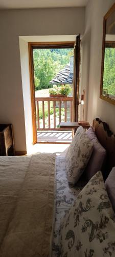 a bedroom with a bed and a large window at Lu Biulè di Pau in Groscavallo