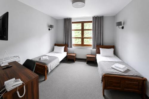 ein Hotelzimmer mit zwei Betten und einem Schreibtisch in der Unterkunft Hotel RED in Ostrowiec Świętokrzyski