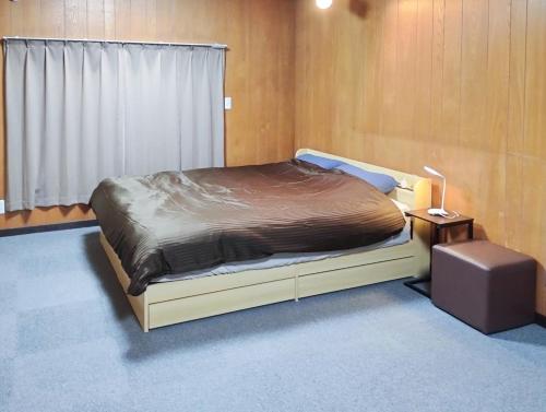 a bedroom with a bed and a table and a window at 和庵-Nagomian- in Kasaoka