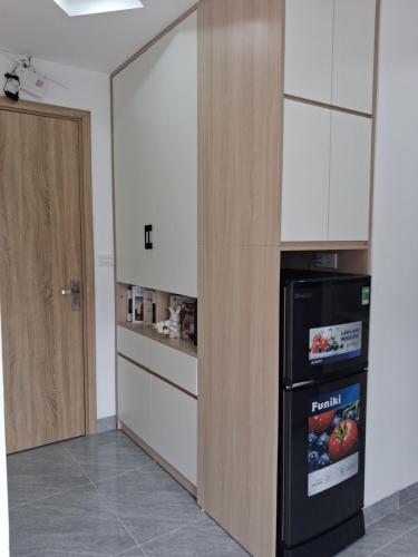 a kitchen with a black refrigerator and white cabinets at Lumina Homes 2 Lai Xá in Thuong Thon