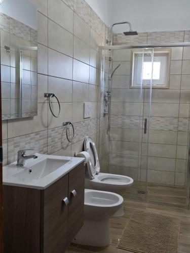 a bathroom with a toilet and a sink and a shower at Residence Canitano Casa Vacanze Giada & David in Scanzano