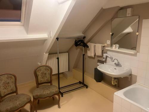 a small bathroom with a sink and two chairs at Hôtel Chandouineau in Redon
