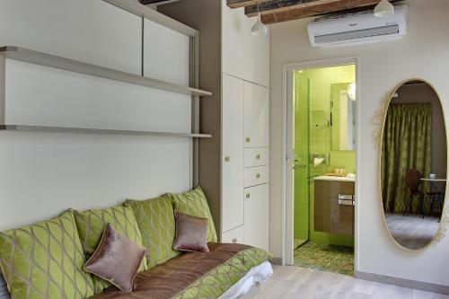 - un salon avec un canapé vert et un miroir dans l'établissement Louvre Apartments, à Paris