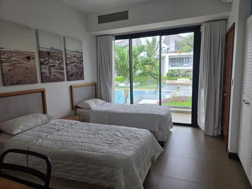 a hotel room with two beds and a large window at Oceanfront in Azuri in Roches Noires