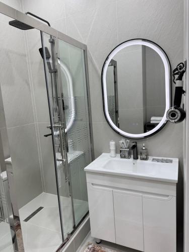 a bathroom with a shower and a sink and a mirror at ЖК Ұлы Дала in Shymkent