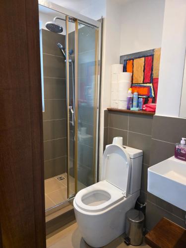 a bathroom with a toilet and a glass shower at Oceanfront in Azuri in Roches Noires
