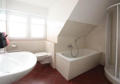 a bathroom with a tub and a toilet and a sink at Hanne-Hus in Kühlungsborn