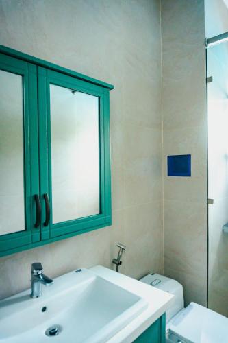 a bathroom with a sink and a mirror and a toilet at Luxury Mi-a Villa LaGi 4pn, huge salted pool, outdoor bbq and kara, up to 20 in Lagi