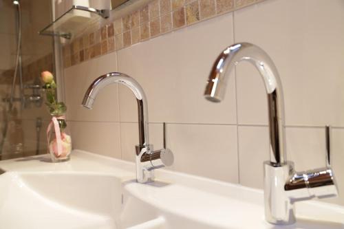 two sinks in a bathroom with two faucets at Ferienwohnung Angerer in Stumm