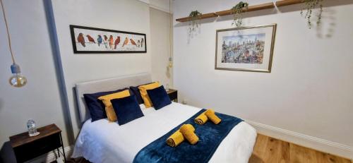 a bedroom with a bed with blue and yellow pillows at Double Bed at Cozy Hailsham in London