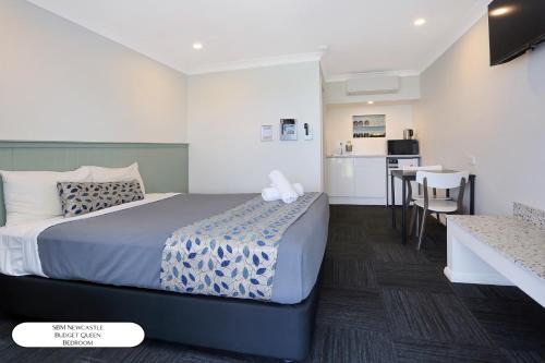 a hotel room with a bed and a kitchen at Surf Beach Motel Newcastle in Newcastle