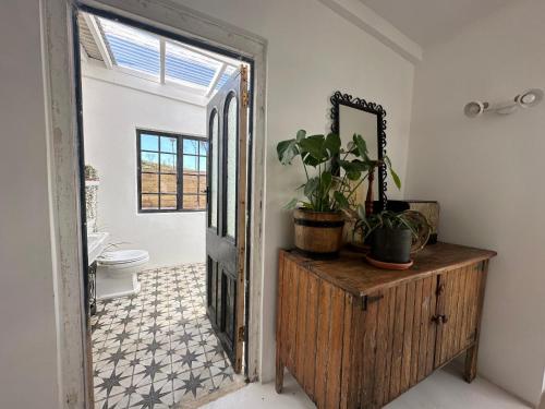 a bathroom with a toilet and a mirror on a dresser at Cornellskop Country Stay in Botrivier
