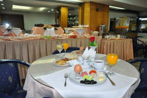 a table with plates of food and glasses of wine at Hotel Kabacam in İzmir