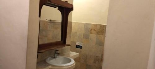 a bathroom with a sink and a mirror at Ashyana Candidasa Beach Resort in Candidasa