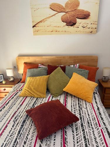 a bed with colorful pillows on top of it at Comfortable apartment with balcony and huge pool in Sucina