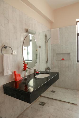 a bathroom with a sink and a mirror at Beach Luxury Hotel in Karachi