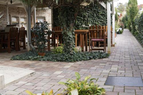 a patio with a table and chairs and a tree at Péterfia Panzió in Debrecen