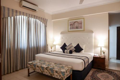 a bedroom with a large bed and a window at Beach Luxury Hotel in Karachi