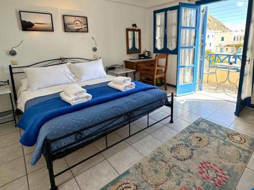 a bedroom with a bed with towels on it at Irigeneia Hotel in Perissa