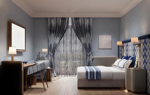 a bedroom with blue walls and a bed and a desk at Steigenberger Inselhotel in Konstanz
