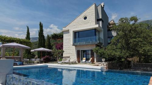 a house with a swimming pool in front of a house at Villa Verra in Pržno
