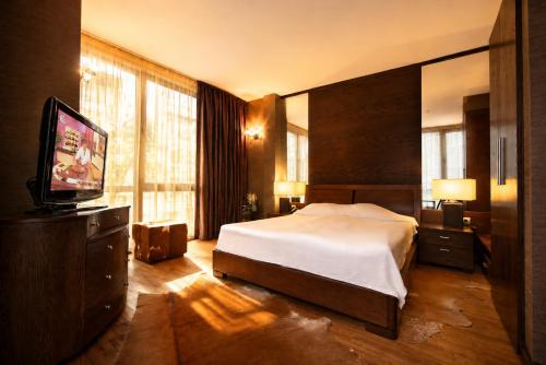 a bedroom with a bed and a flat screen tv at Hotel City Pleven in Pleven
