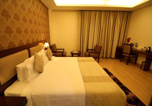 a bedroom with a large bed in a hotel room at Hotel Forest Avenue - Best Luxury Hotel in Dehradun in Dehradun