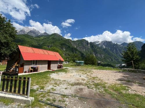 a house with an orange roof with mountains in the background at Stilios guesthouse in Grumas