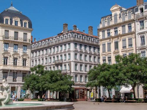 a group of buildings in a city with a fountain at Mercure Lyon Centre Beaux-Arts in Lyon
