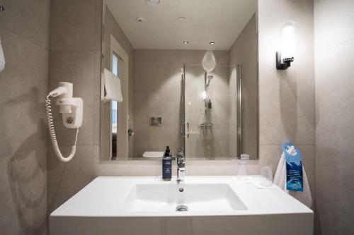 a bathroom with a white sink and a shower at Hotel Loenfjord Loen in Loen