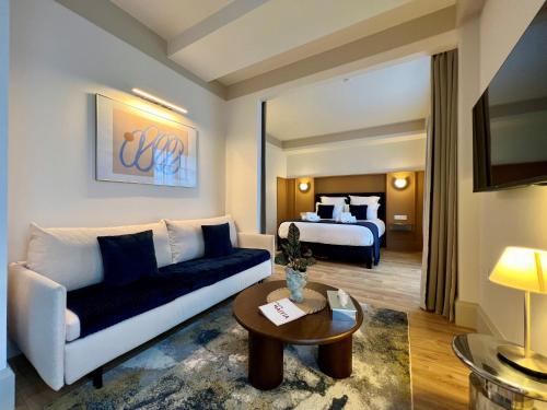 a living room with a couch and a bed at Hôtel Villa Maïtia in Ustaritz