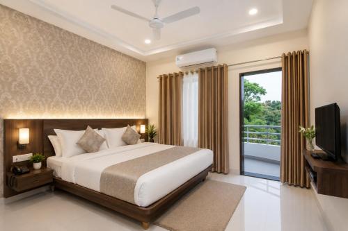 a bedroom with a large bed and a balcony at Strand Resort in Lonavala