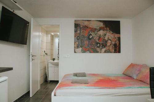 a bedroom with a bed and a painting on the wall at Studio Pod hruško in Kobarid