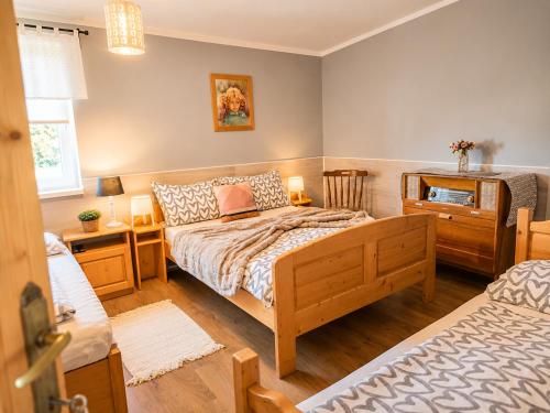 a bedroom with a bed and a desk with a window at Penzión U Koníka in Liptovský Ján