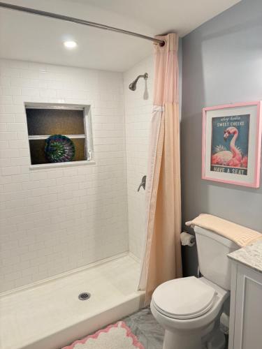 a bathroom with a shower and a toilet and a tub at Coastal Bungalows--The Flamingo Bungalow in Fort Lauderdale