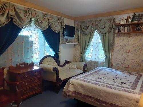 a bedroom with two beds and a chair and a table at Hungry Moose B and B in Kasilof