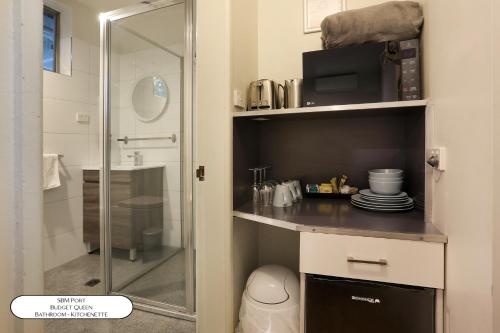 a small bathroom with a shower and a microwave at Surf Beach Motel Port in Port Macquarie