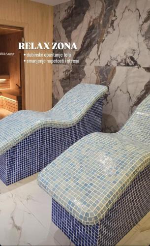 two blue wicker chairs in front of a stone wall at Meandri in Nova Varoš