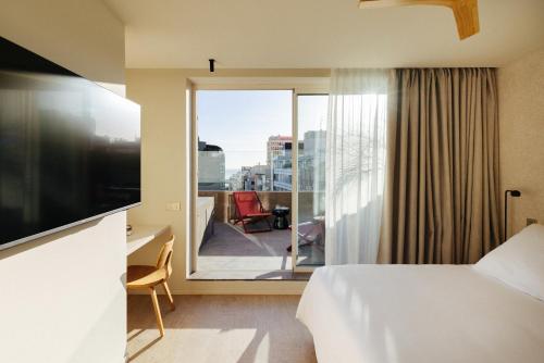 a hotel room with a bed and a view of a balcony at Hotel Taro Santa Cruz in Santa Cruz de Tenerife