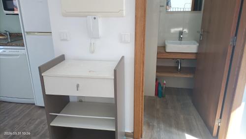 a small kitchen with a sink and a white cabinet at Casa Bisavós de Coelhosa in Vale de Cambra