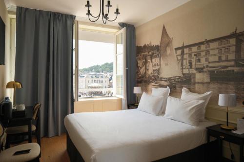 a hotel room with a bed and a window at Best Western Le Cheval Blanc -Vue sur le port-plein centre ville in Honfleur