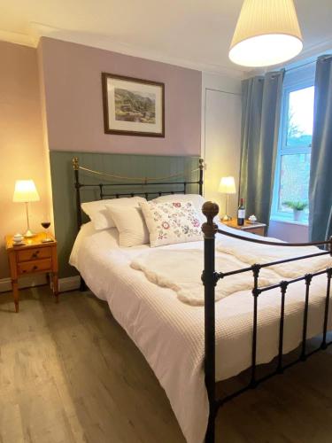 a bedroom with a bed and two lamps and a window at Welsh Yard Retreat in Penrith
