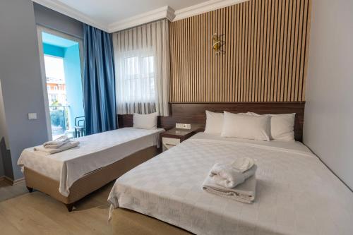 a hotel room with two beds and a window at Citrus Urban Hotel in Antalya