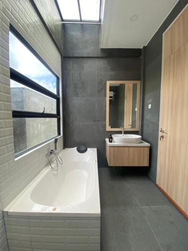 a bathroom with a large tub and a sink at Svaha Ubud Villas in Siantan