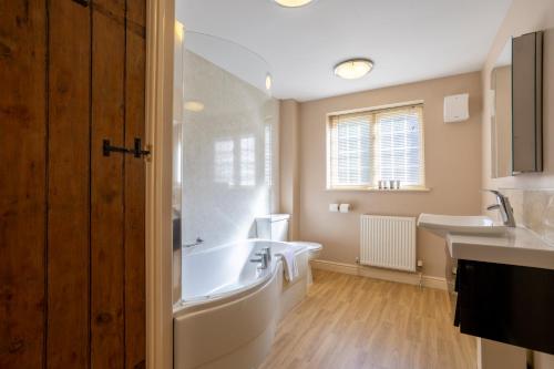 a bathroom with a tub and two sinks and a bath tub at Mount Pleasant Hotel Self-Catering Cottages in Doncaster