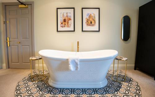 a bath tub sitting on top of a rug in a room at The Gonville Hotel, a member of Radisson Individuals in Cambridge