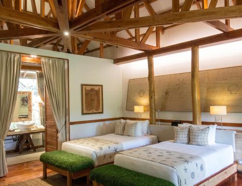 two beds in a room with wooden ceilings at Donatela Resort and Sanctuary in Panglao Island
