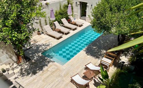 an overhead view of a swimming pool with chaises and chairs at Thirty8 Heritage House in Chania