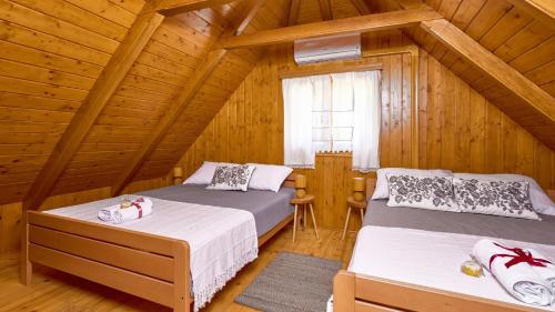 a bedroom with two beds in a wooden cabin at Villa Velika by Villas Guide in Pisarovina