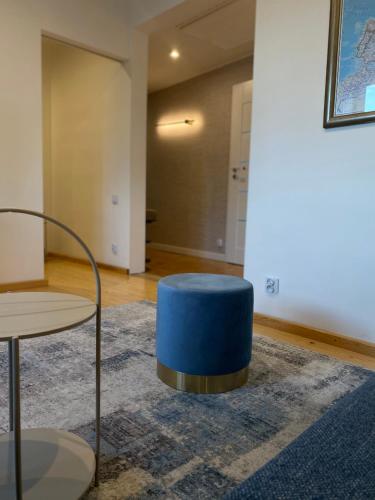 a blue ottoman sitting on a rug in a room at Apartamenty Plac Moniuszki 11 City Center in Kielce